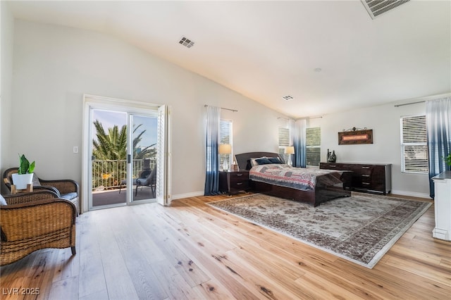 bedroom featuring multiple windows, access to outside, visible vents, and vaulted ceiling