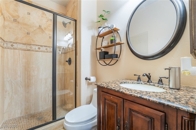 full bath featuring a stall shower, vanity, and toilet