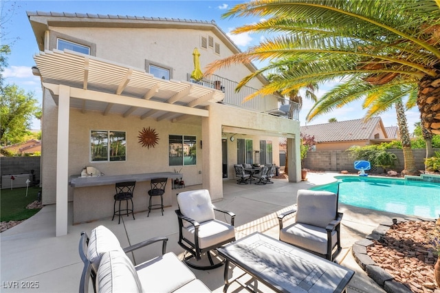 exterior space with a patio area, outdoor dry bar, a fenced backyard, a fenced in pool, and an outdoor hangout area