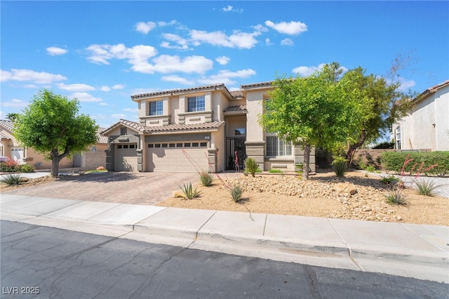 view of front facade featuring a tiled roof, a garage, stucco siding, and decorative driveway