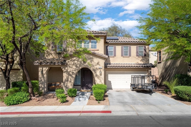 mediterranean / spanish-style house featuring a tile roof, concrete driveway, a garage, stucco siding, and roof mounted solar panels