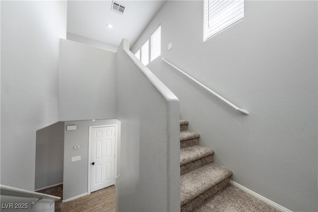 stairway with baseboards and visible vents