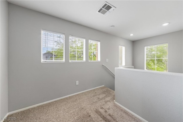 carpeted empty room featuring plenty of natural light, baseboards, visible vents, and recessed lighting