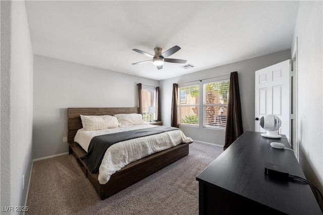 carpeted bedroom with visible vents, baseboards, and a ceiling fan