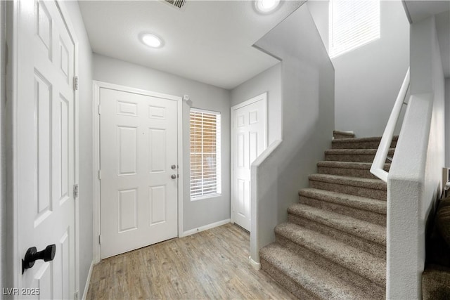 entryway with baseboards, stairs, recessed lighting, and light wood-type flooring