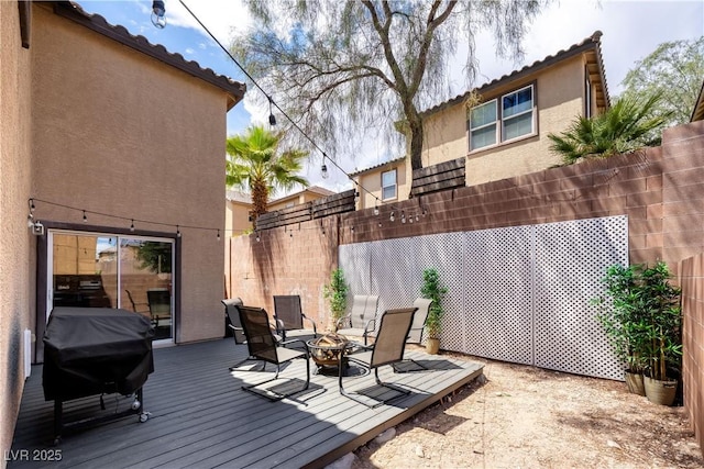 deck featuring fence, area for grilling, and a fire pit