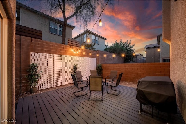 deck featuring a fenced backyard, grilling area, and outdoor dining area