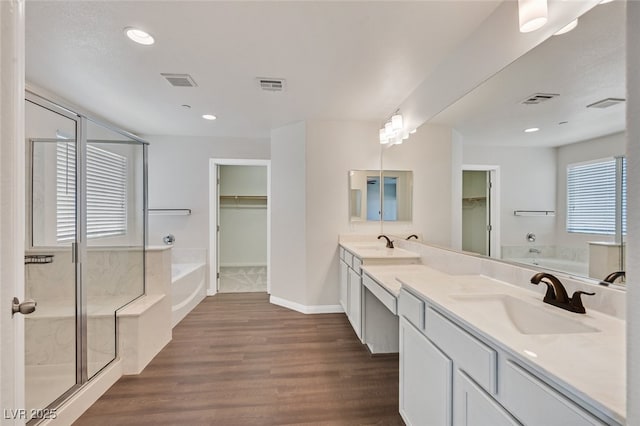 2486 Dragon Fire Ln, Henderson, NV 89052 - full bathroom with a garden tub, double vanity, wood finished floors, a walk in closet, and recessed lighting