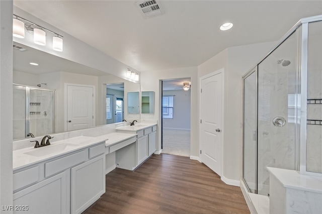 2486 Dragon Fire Ln, Henderson, NV 89052 - full bathroom with a stall shower, double vanity, wood finished floors, recessed lighting, and baseboards