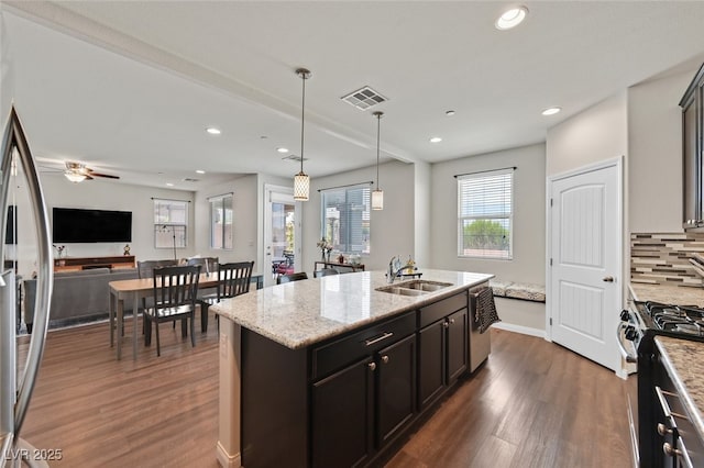2486 Dragon Fire Ln, Henderson, NV 89052 - kitchen featuring a sink, visible vents, dark wood finished floors, an island with sink, and appliances with stainless steel finishes