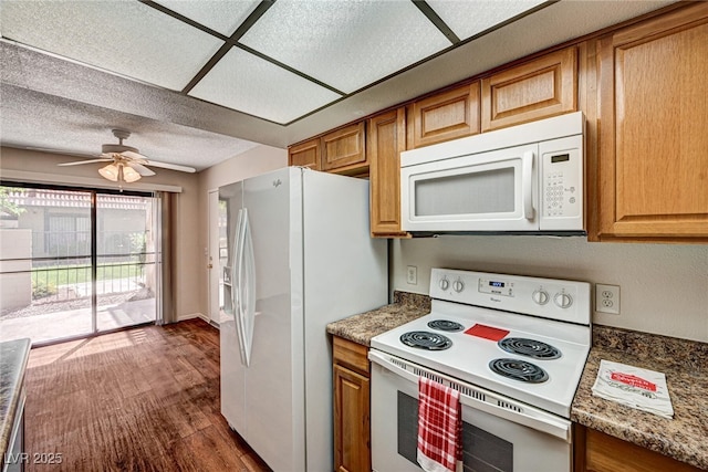 kitchen with dark wood-style flooring, a ceiling fan, brown cabinets, and white appliances