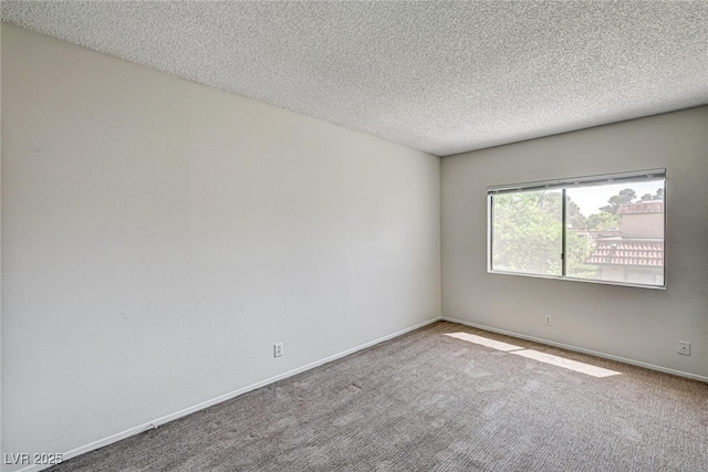 carpeted spare room with baseboards and a textured ceiling