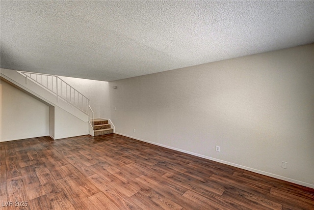 interior space featuring a textured ceiling, dark wood-type flooring, baseboards, and stairs