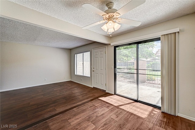 empty room with baseboards, ceiling fan, a textured ceiling, and wood finished floors