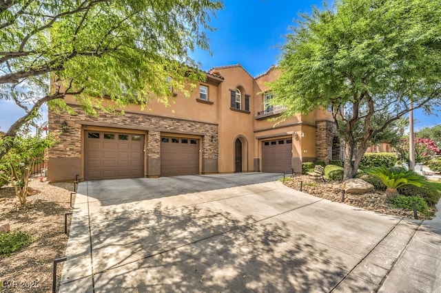 409 Lake Windemere St, Las Vegas, NV 89138 - mediterranean / spanish home featuring an attached garage, stone siding, stucco siding, concrete driveway, and a balcony