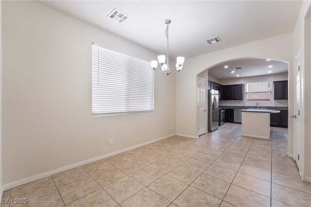 6412 Dimatteo St, Las Vegas, NV 89148 - kitchen with stainless steel appliances, a chandelier, light tile patterned flooring, dark countertops, and open floor plan