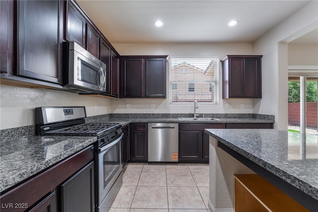 6412 Dimatteo St, Las Vegas, NV 89148 - kitchen featuring stainless steel appliances, light tile patterned floors, dark stone countertops, dark brown cabinets, and recessed lighting