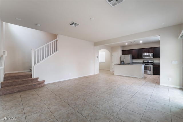 6412 Dimatteo St, Las Vegas, NV 89148 - unfurnished living room featuring light tile patterned floors, recessed lighting, stairway, and arched walkways