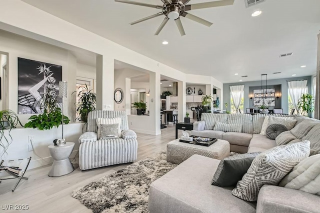 10408 Mezzanino Ct, Las Vegas, NV 89135 - living room with recessed lighting, baseboards, visible vents, ceiling fan with notable chandelier, and light wood-type flooring