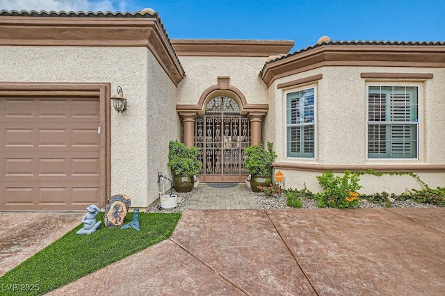 10408 Mezzanino Ct, Las Vegas, NV 89135 - property entrance with an attached garage, stucco siding, and a gate