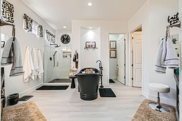 10408 Mezzanino Ct, Las Vegas, NV 89135 - bathroom featuring wood finished floors, a stall shower, a soaking tub, baseboards, and recessed lighting
