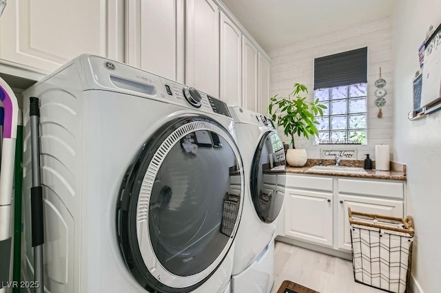 10408 Mezzanino Ct, Las Vegas, NV 89135 - laundry area with cabinet space, washer and clothes dryer, light wood finished floors, and a sink