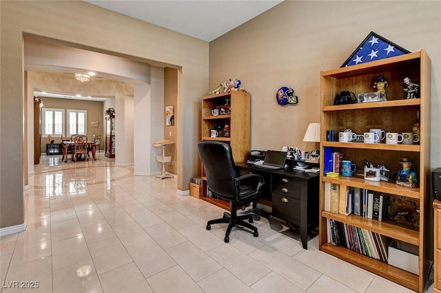 2425 Amatrice St, Henderson, NV 89044 - home office with tile patterned floors, a chandelier, baseboards, and arched walkways