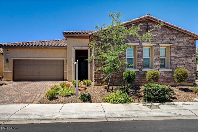 2425 Amatrice St, Henderson, NV 89044 - view of front of property with stone siding, a garage, stucco siding, a tiled roof, and decorative driveway