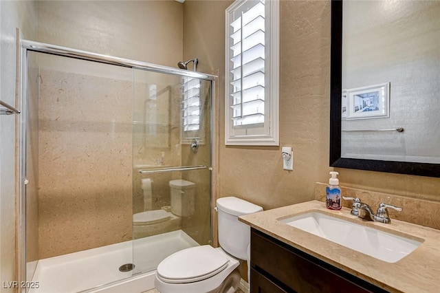2425 Amatrice St, Henderson, NV 89044 - full bathroom featuring a stall shower, vanity, toilet, and a textured wall