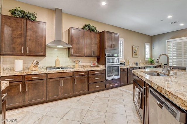 2425 Amatrice St, Henderson, NV 89044 - kitchen featuring a sink, visible vents, wall chimney range hood, appliances with stainless steel finishes, and tasteful backsplash