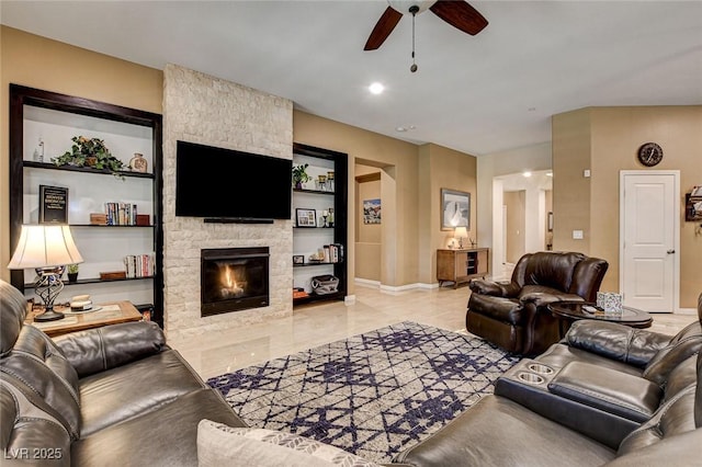 2425 Amatrice St, Henderson, NV 89044 - living room featuring a stone fireplace, baseboards, and a ceiling fan