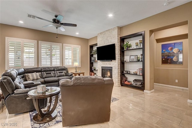 2425 Amatrice St, Henderson, NV 89044 - living area with visible vents, built in shelves, a fireplace, ceiling fan, and baseboards