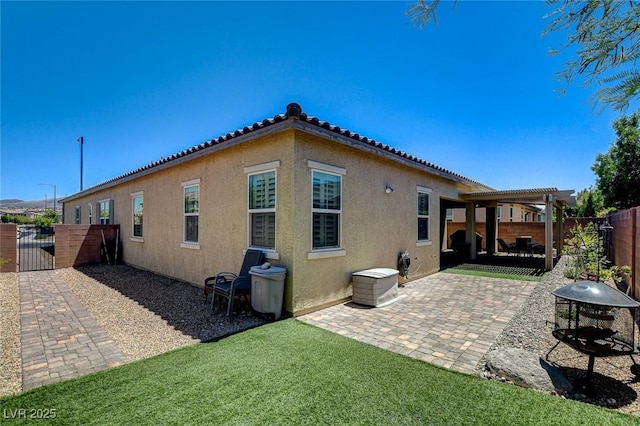 2425 Amatrice St, Henderson, NV 89044 - rear view of house featuring a patio, stucco siding, a pergola, a tile roof, and a fenced backyard