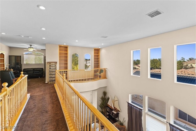 11132 Ferragamo Ct, Las Vegas, NV 89141 - corridor with dark colored carpet, an upstairs landing, visible vents, and a healthy amount of sunlight