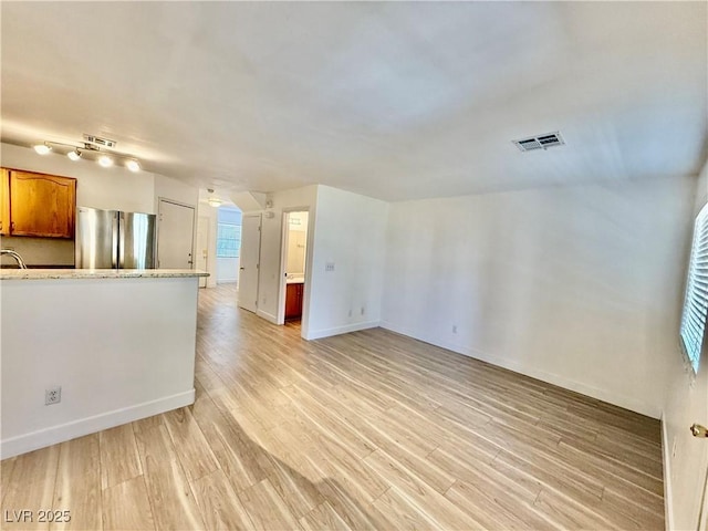 2524 Charleville Ave Unit 102, Las Vegas, NV 89106 - unfurnished living room with baseboards, visible vents, and light wood-style floors