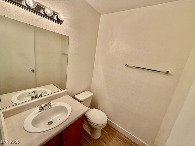 2524 Charleville Ave Unit 102, Las Vegas, NV 89106 - bathroom with vanity, toilet, baseboards, and wood finished floors