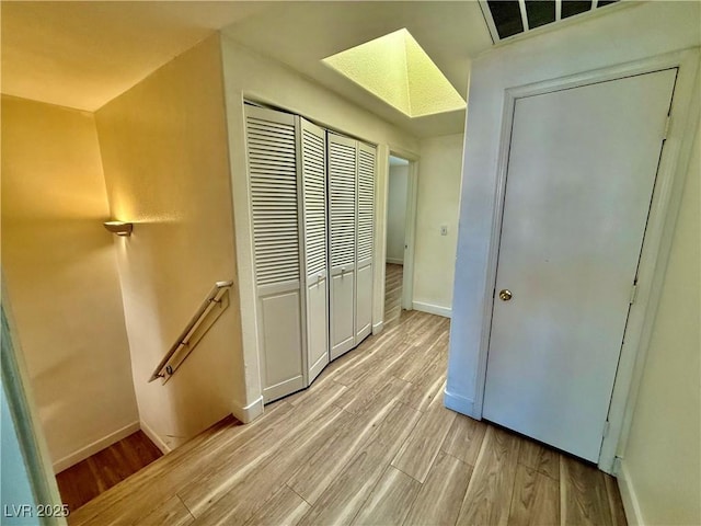 2524 Charleville Ave Unit 102, Las Vegas, NV 89106 - hallway with light wood finished floors, an upstairs landing, a skylight, visible vents, and baseboards