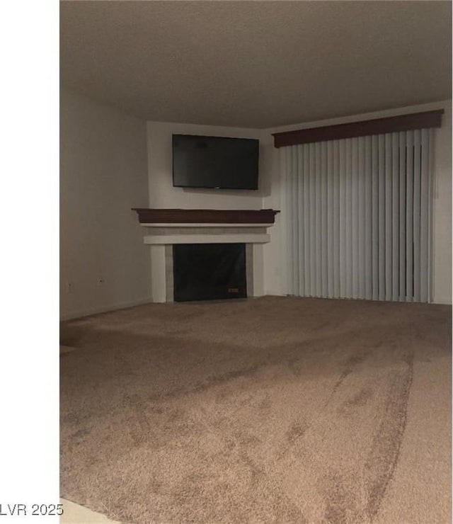 unfurnished living room featuring a fireplace and carpet floors
