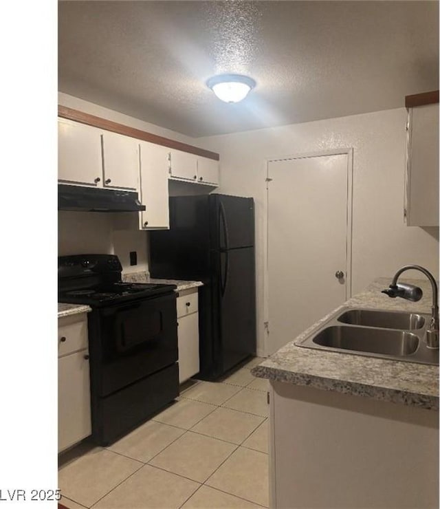 kitchen featuring light tile patterned floors, a sink, white cabinets, black appliances, and under cabinet range hood