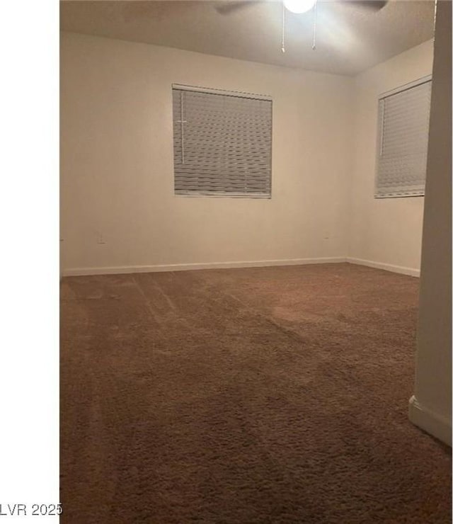 carpeted empty room featuring baseboards and ceiling fan