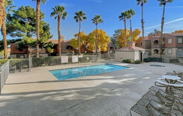 community pool featuring a residential view, a patio area, and fence