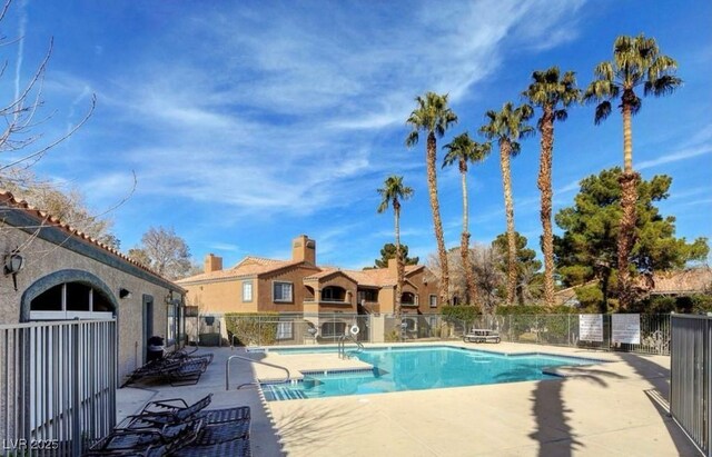 community pool with fence and a patio