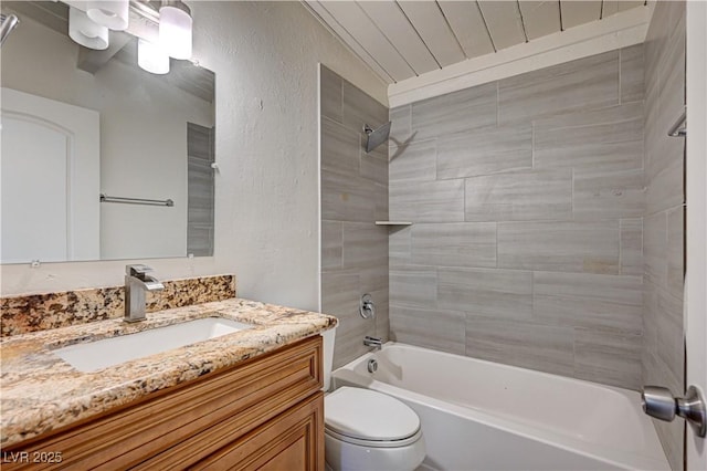 full bath featuring toilet, vanity, tub / shower combination, and a textured wall