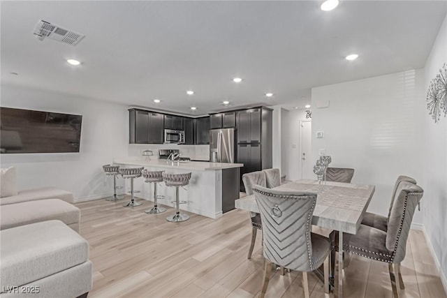 dining space with light wood-style floors, visible vents, baseboards, and recessed lighting