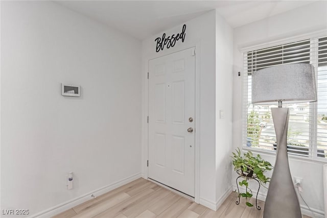 foyer featuring baseboards and light wood-type flooring