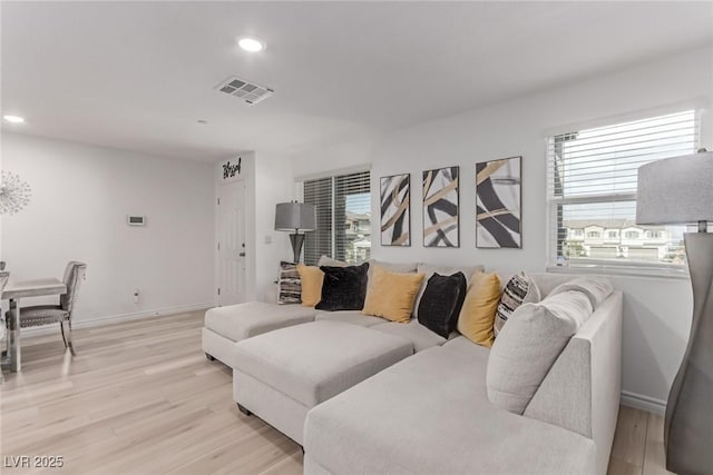 living room featuring baseboards, recessed lighting, light wood-style flooring, and visible vents