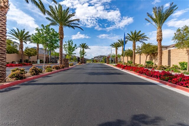 6150 Foxes Dale St, Las Vegas, NV 89166 - view of asphalt road featuring curbs, a gated entry, and a residential view