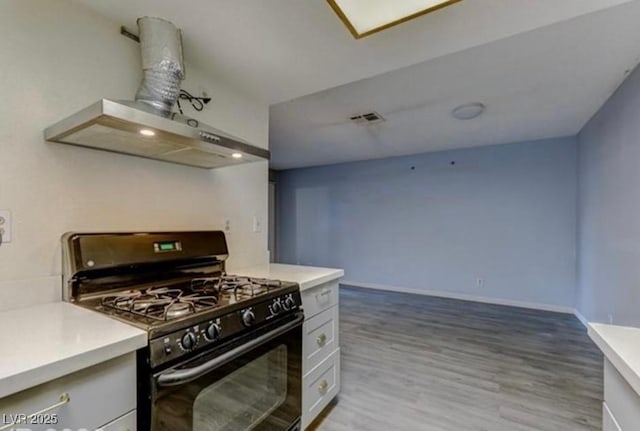 kitchen featuring gas stove, light countertops, range hood, and light wood-style floors