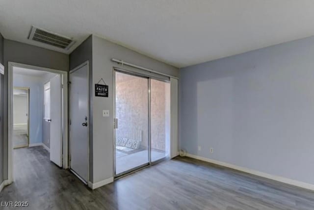 interior space with visible vents, wood finished floors, and baseboards