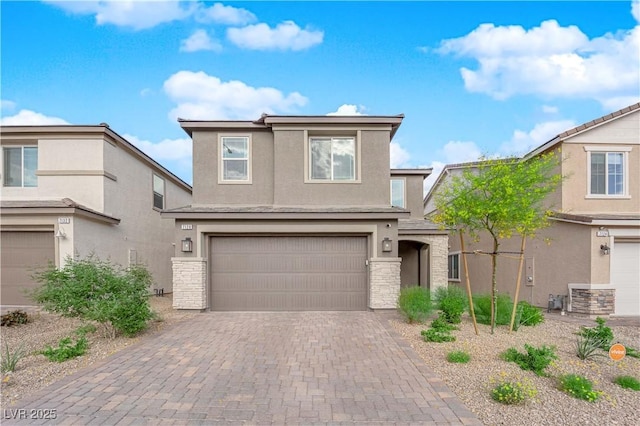 traditional-style house with stone siding, stucco siding, an attached garage, and decorative driveway